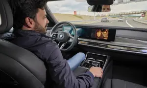 Uomo rilassato in auto, guarda un film mentre il sistema di **traffic jam assist** gestisce la guida in coda.