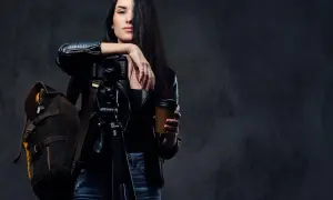 Kobieta z aparatem na statywie i kubkiem kawy, gotowa do uchwycenia niezwykłych kadrów. Opanowała zaawansowane techniki fotograficzne.