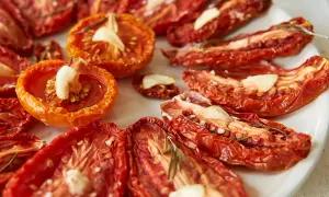 Getrocknete Tomaten mit Knoblauch und Rosmarin auf einem Teller.