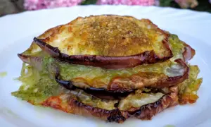 Tramezzini con melanzane grigliate, pesto e formaggio fuso, un'esplosione di sapori mediterranei su un piatto bianco.