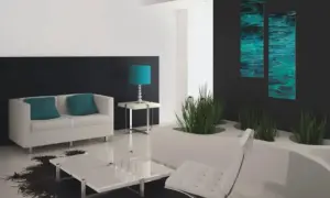 Nowoczesny salon z białymi meblami i turkusowymi dodatkami. Ściana za kanapą pomalowana na ciemny grafit, kontrastująca z jasnymi ścianami. Obrazy z motywem wody dodają głębi. Farba satynowa a matowa - wybór wykończenia ścian ma znaczenie.