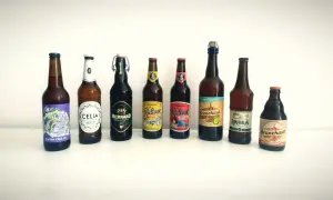 Rząd butelek piwa bezglutenowego na białym tle.