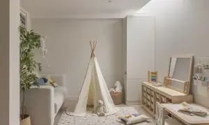 Ideas para un cuarto de juegos: tienda de campaña, sofá, alfombra, mesa de actividades y estanterías de madera.