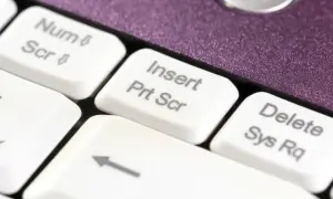 Klawisz "Insert Prt Scr" na białej klawiaturze, gotowy do zrobienia zrzutu ekranu.