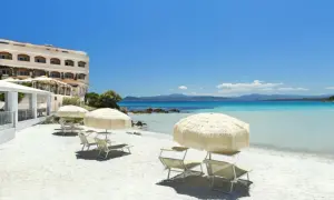 Rajska plaża na Sardynii. Biały piasek, turkusowa woda i hotel. Idealne miejsce na relaks.