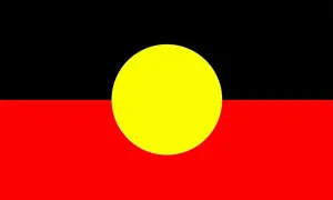Flaga Australii Aborygenów: czarny pas u góry, czerwony na dole, a pośrodku żółte koło symbolizujące słońce.