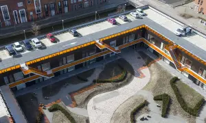 Moderne Architektur mit begrüntem Innenhof und Parkplätzen. Die Dachpappe wurde begehbar gemacht und dient als Parkfläche.