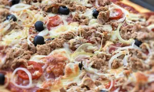 Pyszna pizza z tuńczykiem, oliwkami, cebulą i pomidorami, obficie posypana serem. Idealna na szybki obiad.