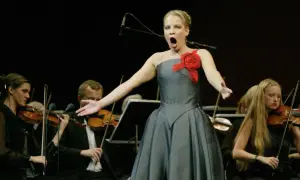 Wokalistka w operze Pucciniego śpiewa z pasją, podczas gdy orkiestra smyczkowa akompaniuje jej w tle.