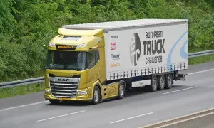 Un camion jaune DAF XF participe au European Truck Challenge, sur une autoroute bordée d'arbres.