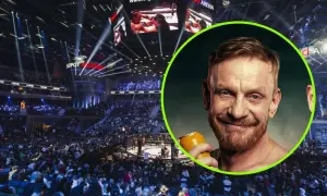 Tomasz Matysiak z puszką piwa na tle hali widowiskowej z widownią i ringiem.