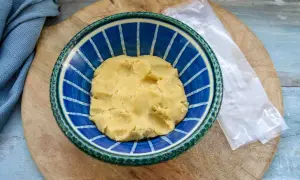 Frischer quiche teig in einer blauen Schüssel, bereit für die Zubereitung einer herzhaften Tarte.