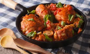 Pezzi di pollo succulenti in umido con pomodoro, olive e funghi, un delizioso coniglio alla cacciatora servito in padella.