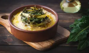 Polenta cremosa con cicoria in padella, un piatto rustico e saporito.