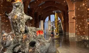Sculptures de Niki de Saint Phalle, dont un dragon miroitant, dans un musée aux arches de briques.