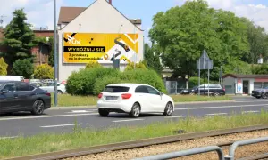 Reklama na ogrodzeniu przepisy: "Wyróżnij się 3 przekazy na jednym nośniku". Jasnożółte tło z grafiką drogi i ikonami.