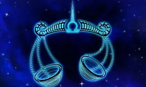 Błękitna waga symbol zodiaku, jakby zrobiona z kamieni szlachetnych, unosi się na tle nocnego nieba pełnego gwiazd.
