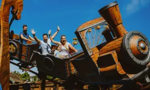 Rodzina na drewnianym rollercoasterze, który wygląda jak lokomotywa. To jeden z największych rollercoasterów w Europie, zapewniający mnóstwo emocji.