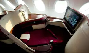 Luxuriöser Sitz im Flugzeug mit Bildschirm, der ein Fußballspiel zeigt. Hier sitzt man bequem, der beste Platz im Flugzeug für eine entspannte Reise.