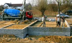 Budowa fundamentów: betonowóz i ekipa przygotowują teren. Czym obsypać fundamenty? Piaskiem i żwirem.