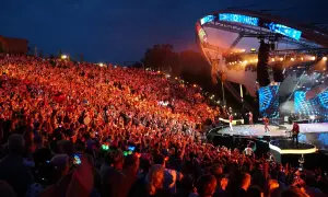 Tłumy rozbawionych ludzi na mrągowo festiwal, oświetlone sceną i kolorowymi światełkami.