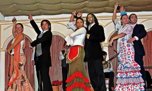 Artistas en escena, aprendiendo flamenco con pasión. Bailarines y músicos crean un espectáculo vibrante.
