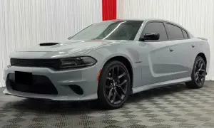Szary Dodge Charger Hellcat z czarnymi felgami i przyciemnianymi szybami stoi na kratkowanej podłodze.