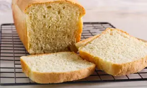 Świeżo upieczony chleb tostowy na kratce, z kilkoma kromkami obok. Idealny na śniadanie, warto sprawdzić chleb tostowy kcal.