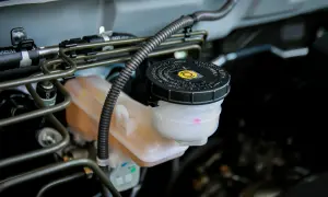 Réservoir de liquide de frein presque vide, avec le couvercle noir marqué "DOT 3".