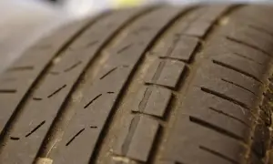 Gros plan sur la bande de roulement usée d'un pneu, signe qu'il est temps de changer ses pneus pour plus de sécurité.