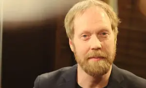 Lars Johan Åge, en man med blont hår och skägg, blickar mot kameran.