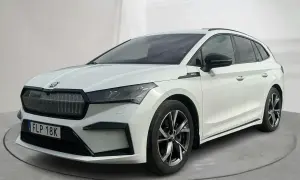 Vit Skoda Enyaq begagnad, en modern elbil med sportig design och snygga fälgar. Perfekt för familjen som söker en hållbar och stilfull transport.