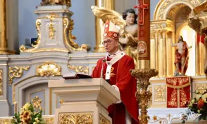 16 kwietnia. Biskup w czerwonej szacie przemawia przy pulpicie w bogato zdobionej świątyni.