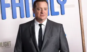 Brendan Fraser w garniturze, z widocznym napisem "FAMILY" w tle. Aktor pokonał chorobę i wrócił na czerwony dywan.