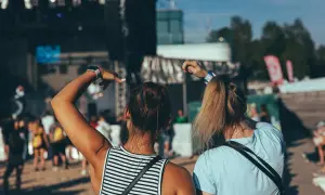 Dwie dziewczyny bawią się na koncercie podczas zielonego festiwalu, unosząc ręce w rytm muzyki.