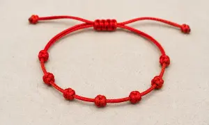 Pulsera roja con siete nudos, cada uno con su propia historia y significado.