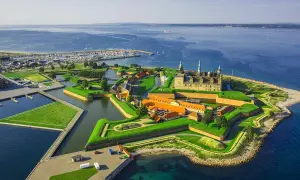 Kronborgs slott vid havet, en stjärnformad fästning med vallgravar och gröna ytor. En idyllisk vy över december i Danmark.