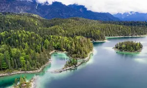 Idyllischer Bergsee mit Inseln, umgeben von dichten Wäldern. Perfekt für einen erfrischenden Tag zum schwimmen.