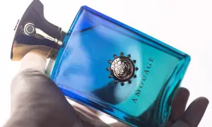 Dłoń trzyma luksusowe perfumy Amouage Figment w niebiesko-turkusowej butelce.