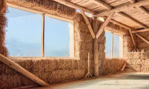 Interno di una struttura con pareti di balle di fieno e tetto in legno. Un esempio di costruzione con materiali ecosostenibili.