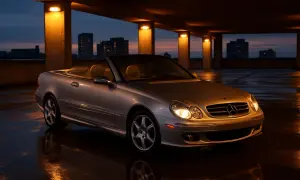 Srebrny kabriolet Mercedes CLK W209 na mokrym parkingu. Dane techniczne tego modelu są imponujące.