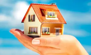 Modellino di casa tenuto in mano, con cielo azzurro sullo sfondo. Simboleggia il prezzo di una casa con usufrutto.
