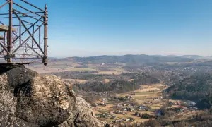 Widok z punktu widokowego na rudawy janowickie. W dole malownicza dolina z zabudowaniami i lasami.