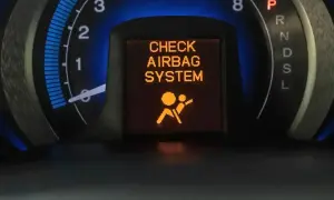 Na desce rozdzielczej świeci się pomarańczowa kontrolka poduszki powietrznej z napisem "CHECK AIRBAG SYSTEM".