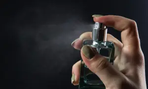 Dłoń rozpyla perfumy. Chcesz wiedzieć, jak sprawdzić, czy perfumy są oryginalne? Zwróć uwagę na detale flakonu i zapach.