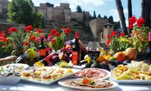 Uczta w jednej z malaga restauracji: tapas, wino i owoce na tle Alcazaby.
