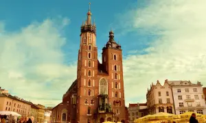Bazylika Mariacka w Krakowie, jedno z najpiękniejszych miejsc historycznych w Polsce, na tle błękitnego nieba z chmurami.