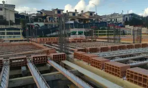 Cantiere edile con mattoni e armature in vista. Si sta preparando il miglior isolante termico per soffitto, con blocchi di laterizio pronti per la posa.
