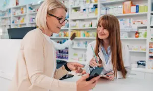 Klientka pokazuje farmaceutce telefon, szukając odpowiedzi na pytania zamknięte przykłady.