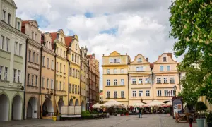 Kolorowe kamienice przy deptaku w Jeleniej Górze, z kawiarnianymi ogródkami i kwitnącym kasztanowcem.